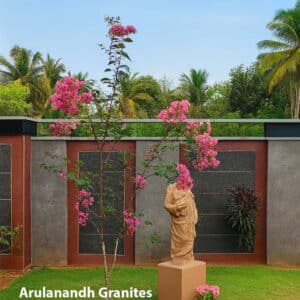 Decorative granite and panel wall work with classical statue and flowering tree in landscaped garden by Arulanandh Granites