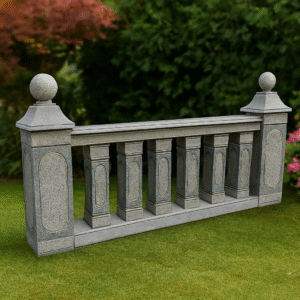 Granite balustrade with decorative pillars and spherical finials, showcased in a landscaped garden setting.